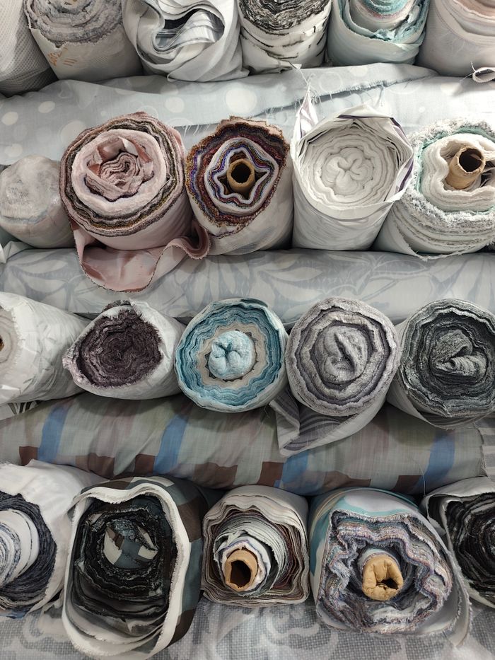 Vibrant rolls of fabric stacked neatly accentuating textile diversity.