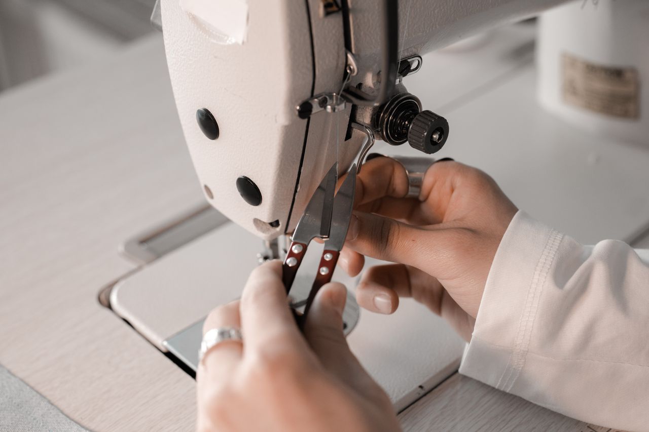 Detail shot of hands using a sewing machine with close precision.
